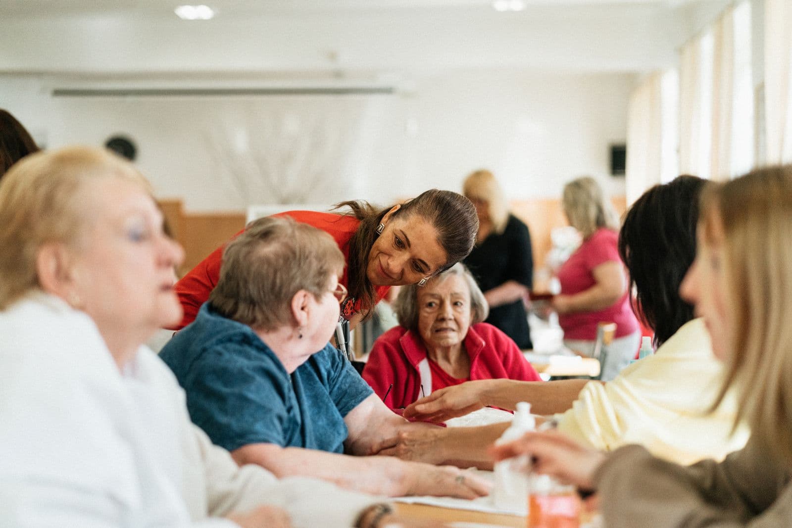 Carers and older people sharing a meal together around a table